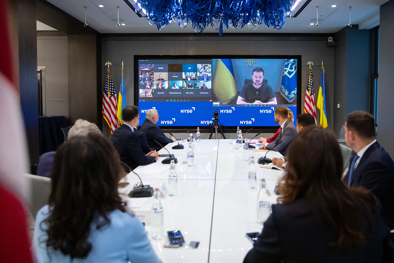 people sitting at a table virtually speaking to Ukrainian president