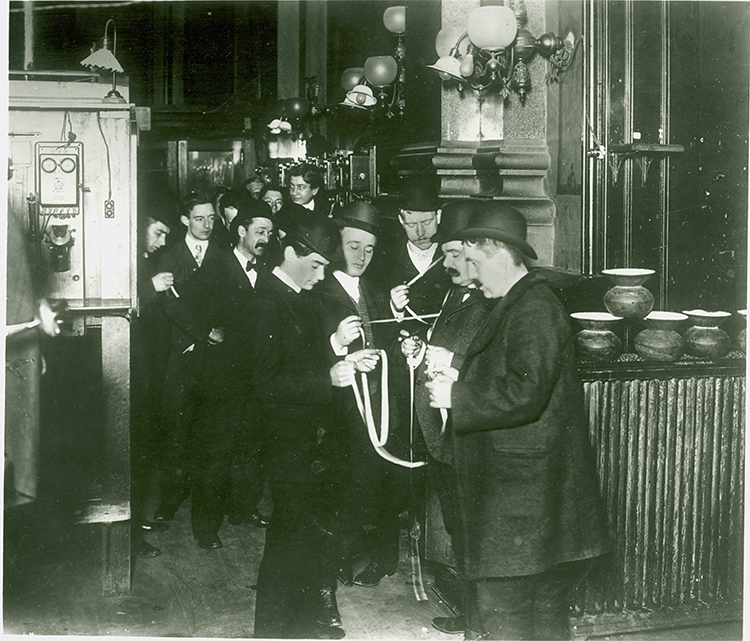 Brokers in 1899 examine recent sales coming across the stock ticker at the NYSE.
